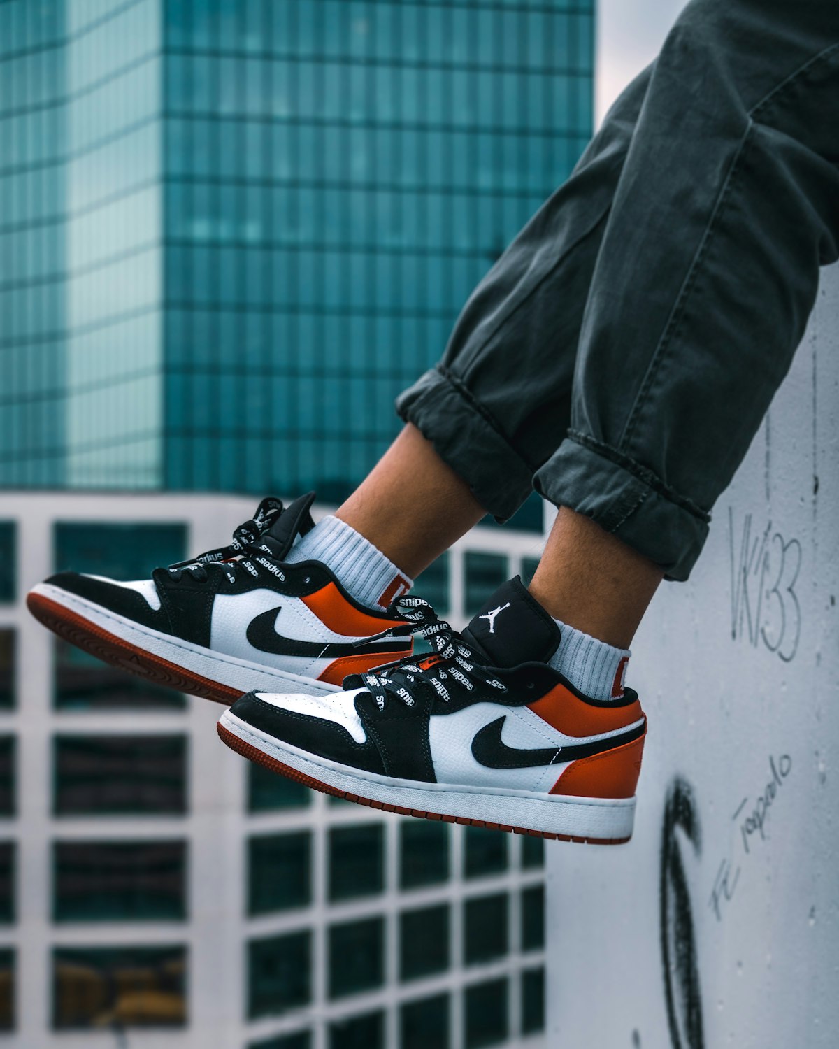 Air Jordan 1 low-top sneakers worn on a ledge