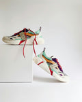White and orange athletic shoes on a shoebox