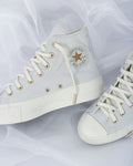 Pair of white leather sneakers on a plain background